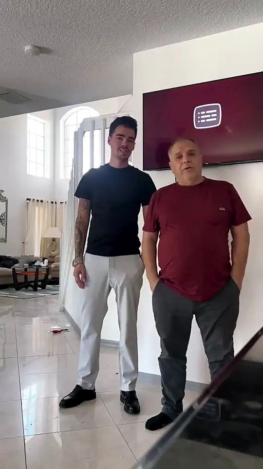 Someone from Ozzifloors with a homeowner in his living room, on the pale tile floor