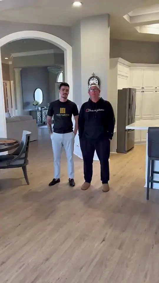 Someone from Ozzifloors with a homeowner in his open-plan kitchen and living room, on the new wide plank floor