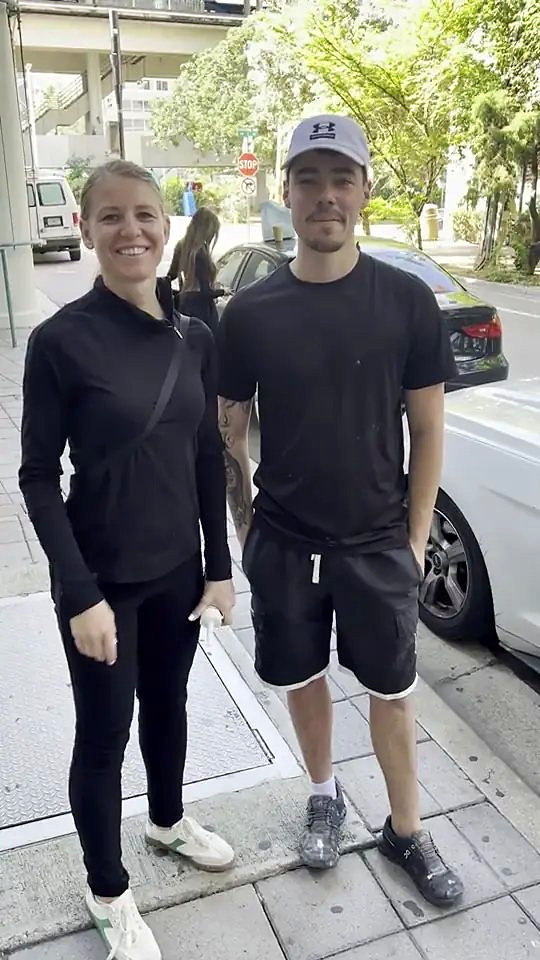 Someone from the Ozzifloors team standing with a customer on the sidewalk outside her building