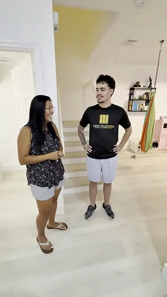 Someone from Ozzifloors with a homeowner in her bright open living room, on the pale finished floor