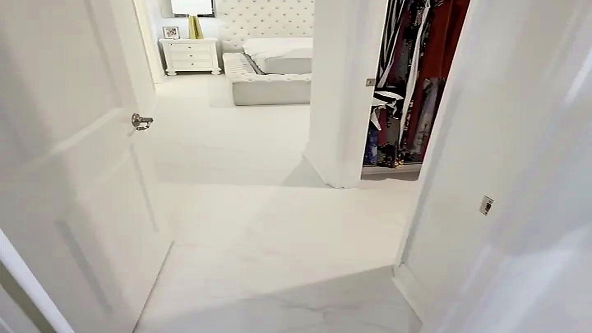 Marble-look porcelain tile flooring running into a furnished South Florida bedroom