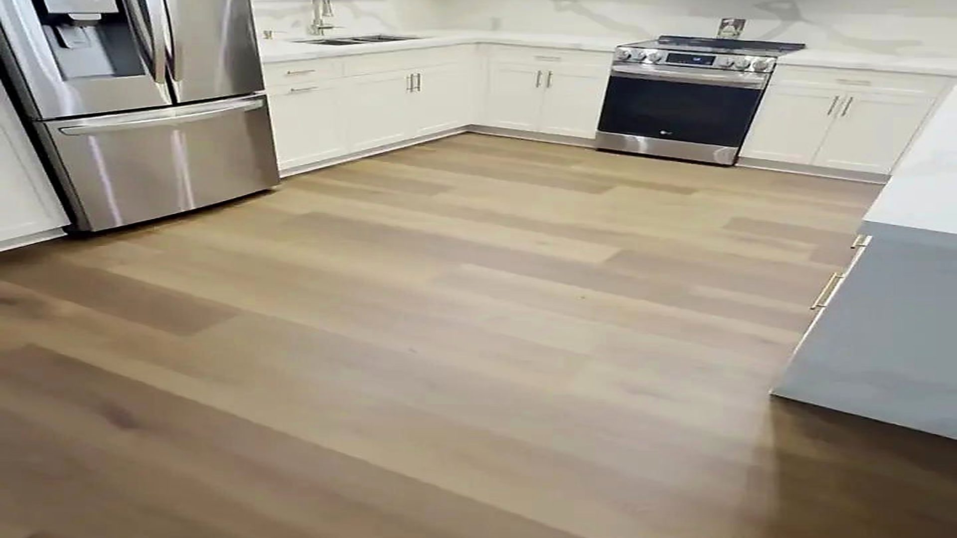 Warm oak-look vinyl plank flooring in a finished South Florida kitchen, installed by Ozzifloors