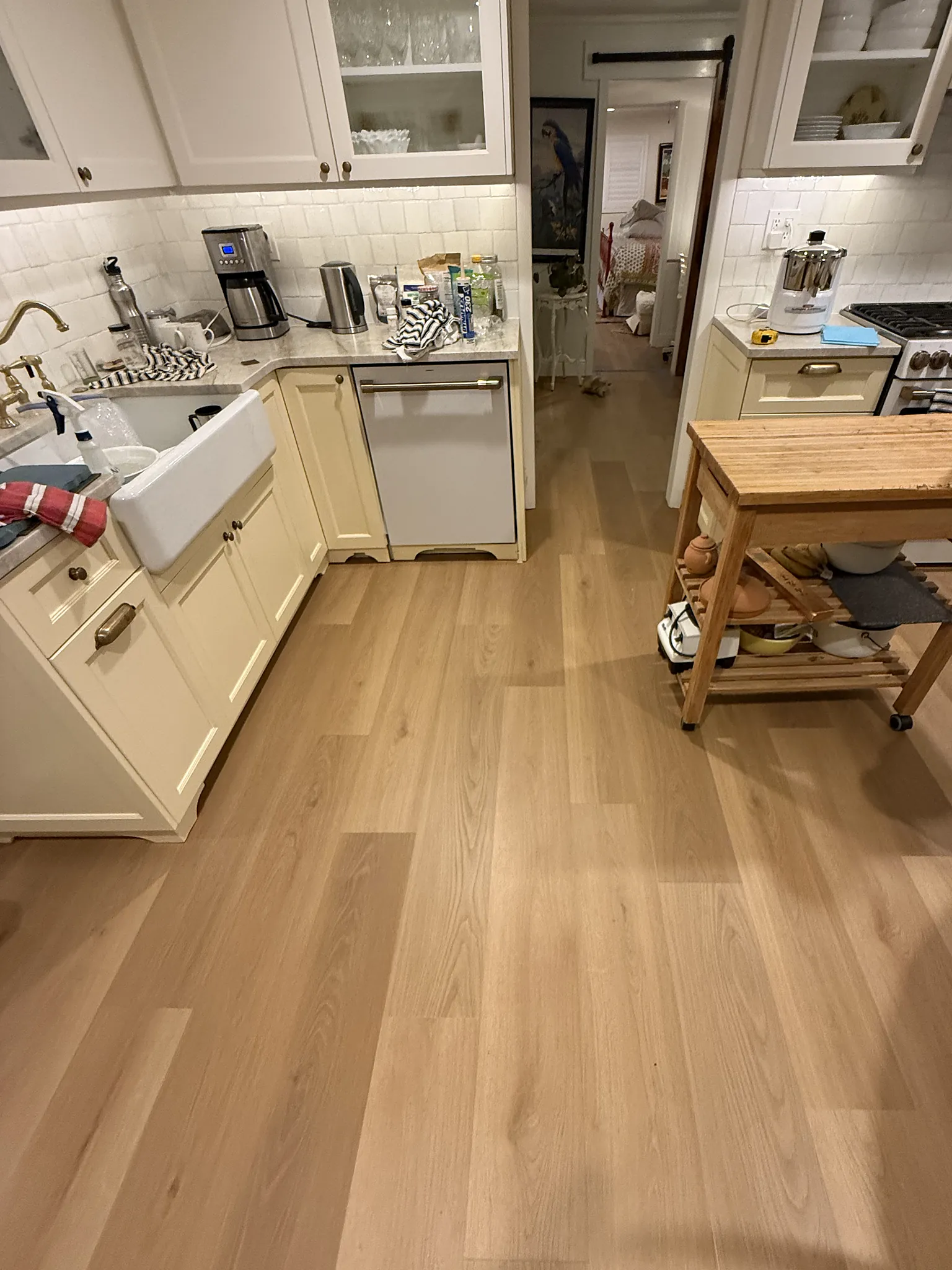 Wide light oak plank running the length of a white farmhouse kitchen